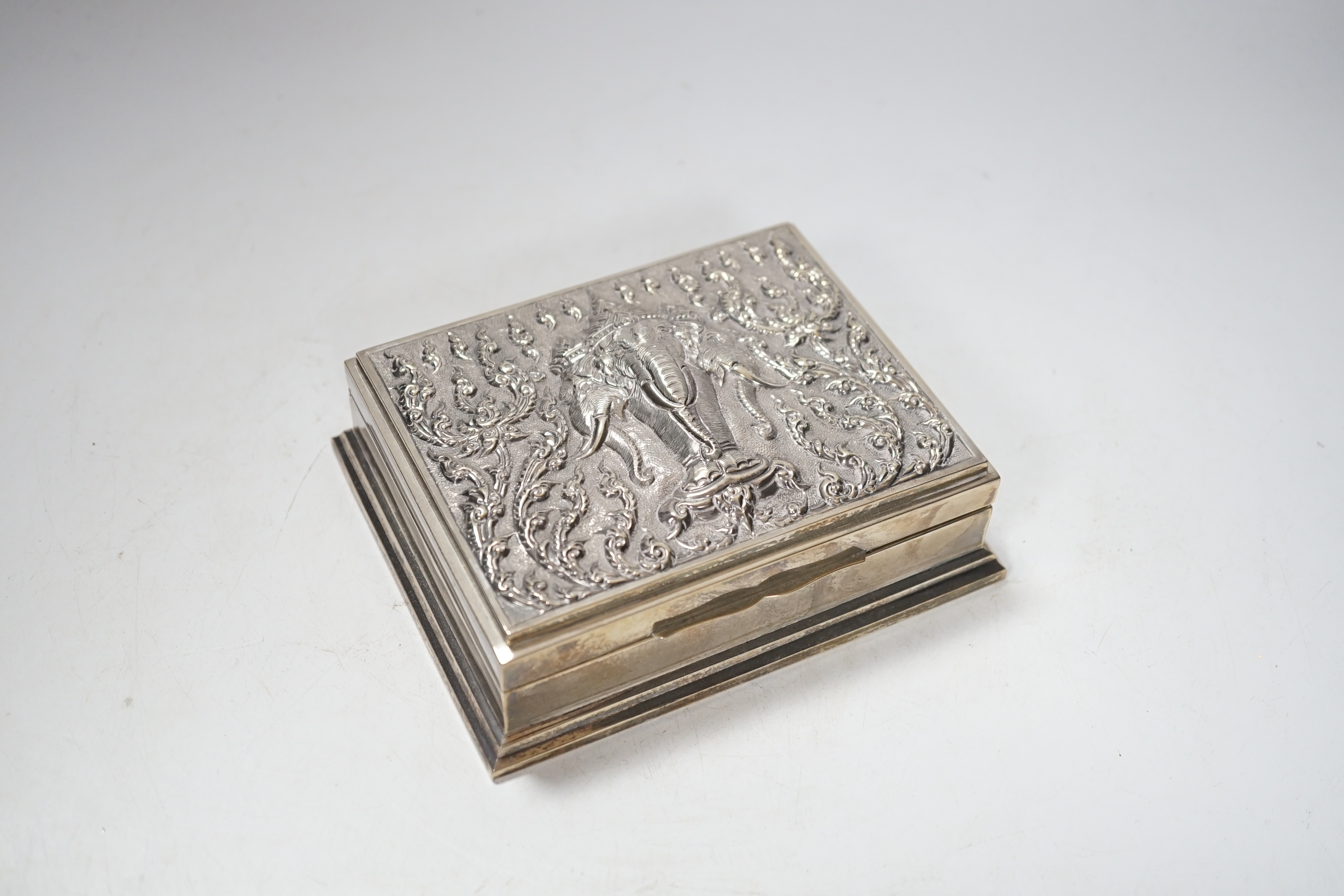 A Thai white metal cigarette box, stamped sterling, 14cm, and a similar sterling overlaid photograph frame, width 16cm